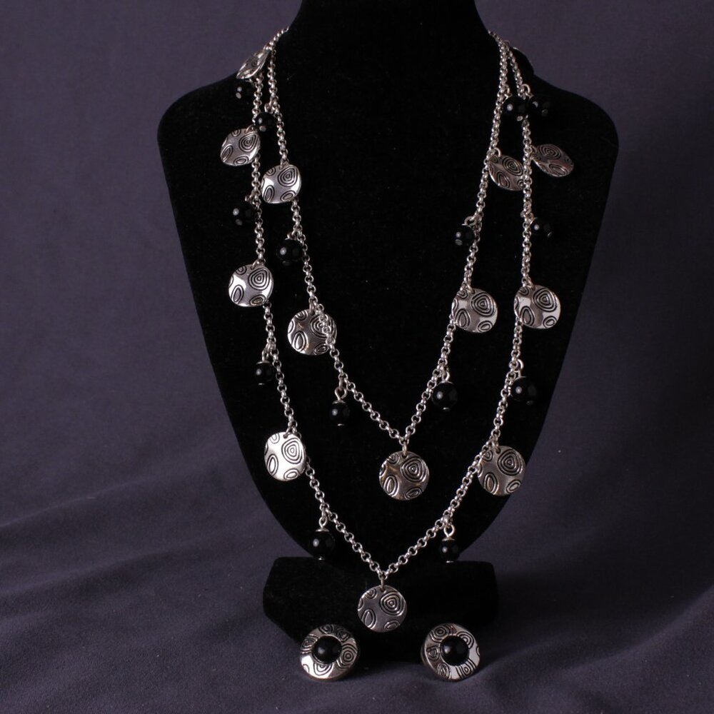Silvertone long chain with multi embellished discs with black crystal accents